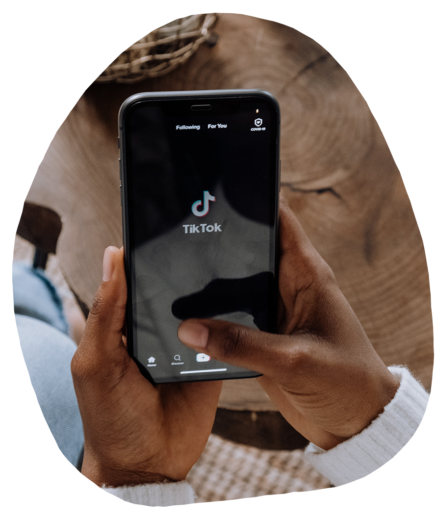 Close up of person holding phone and launching TikTok app